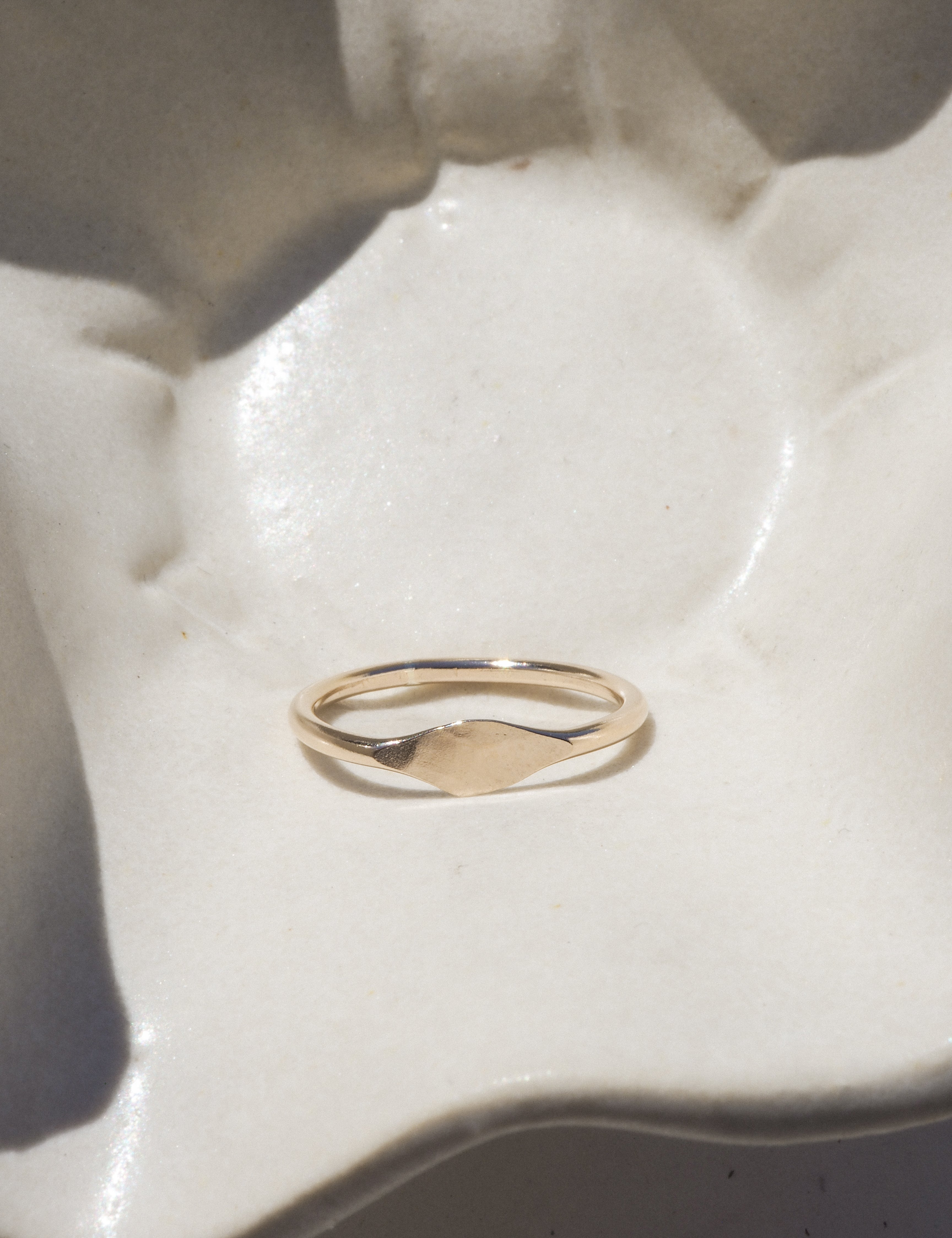 Gold ring on a white ceramic dish