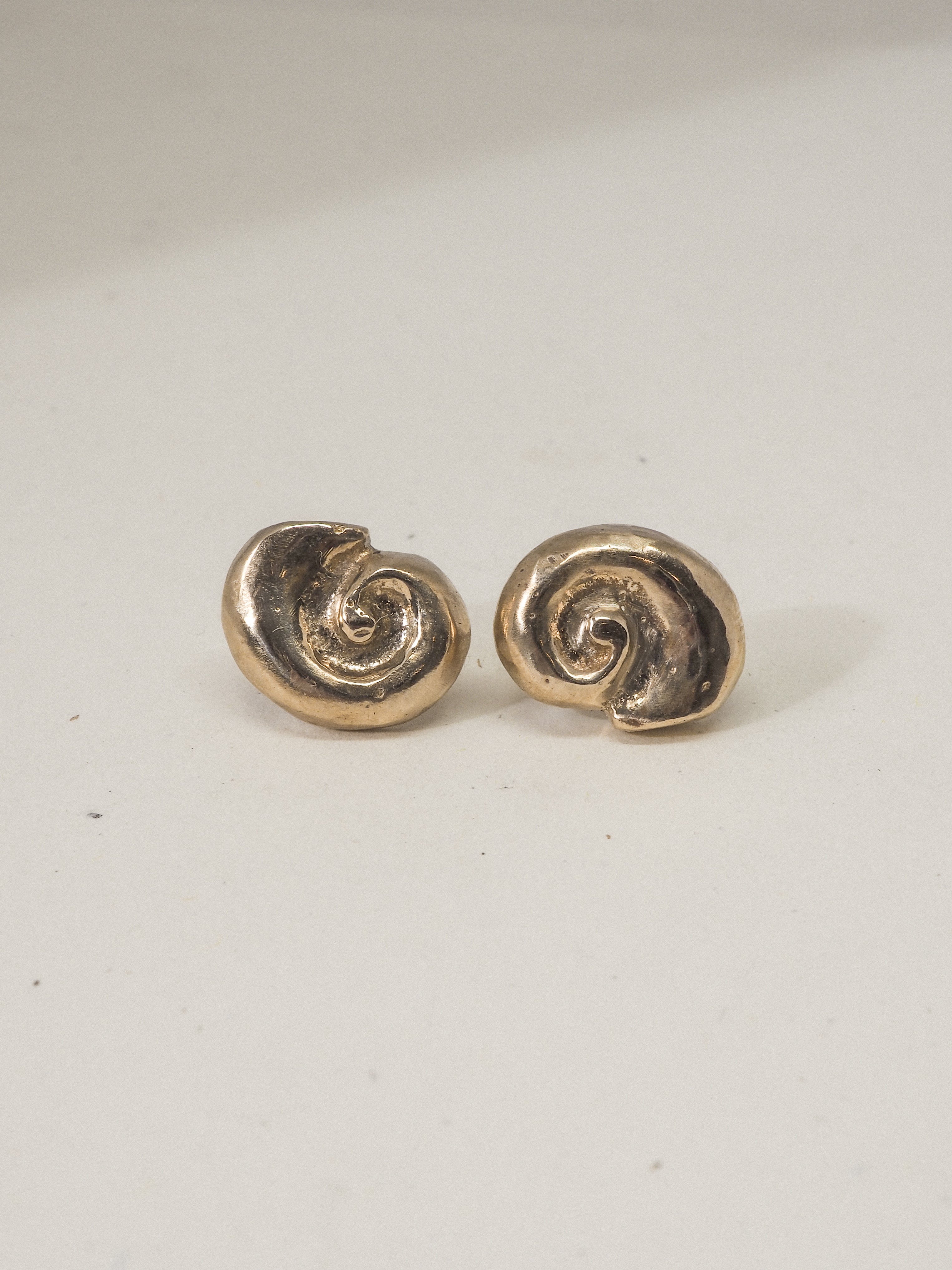 Pair of gold spiral earrings on a white background